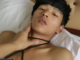 Tall and well-endowed Asian boys in gay BDSM bondage giving each other handjobs