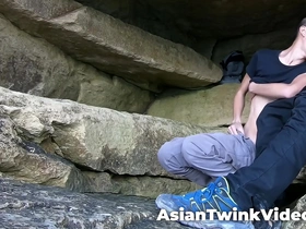 Young gay couple of Asian and white twinks having sex in a picturesque lagoon